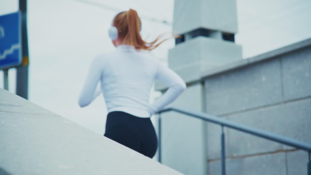 Woman running up stairs while listening to music