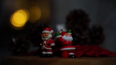 Zwei-Kleine-Weihnachtsnikolaus-Stehen-Als-Dekoration-Auf-Einem-Holztisch-Und-Ein-Schatten-Bewegt-Sich-Ständig-Durch-Den-Dunklen-Raum