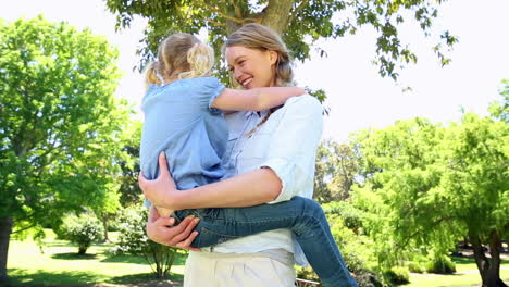 Glückliche-Mutter-Hält-Ihr-Kleines-Mädchen-Im-Park