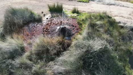 hot water geyser at fuendejalon spain with water and iron deposits.