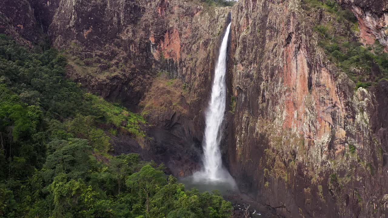 hermosa cascada de wallaman falls rastreo aéreo hacia atrás con selva tropical, queensland
