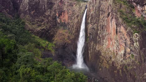 beautiful wallaman falls waterfall aerial tracking backward with rainforest, queensland