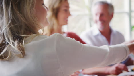 Young-adult-woman-sharing-tapas-with-her-friends-at-lunch-in-a-restaurant,-part-of-person