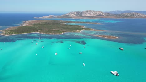 barcos en el mar azul turquesa durante el verano en la pelosa, cerdeña, italia - antena de drones de 4k
