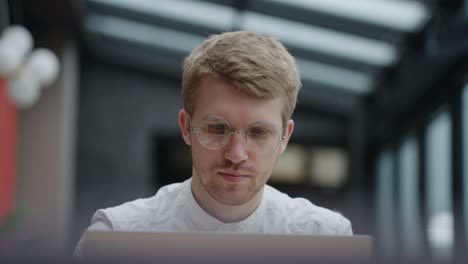 manager is working in office, sending emails by laptop, portrait shot in coworking space