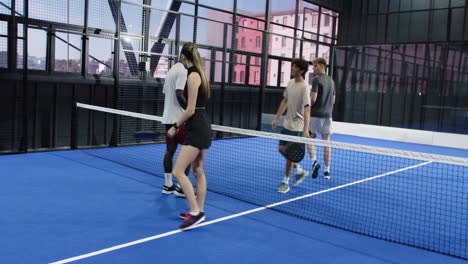 women playing padel tennis on blue court, focusing on competitive match