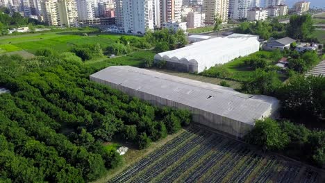 aerial view of a farm and cityscape with greenhouses