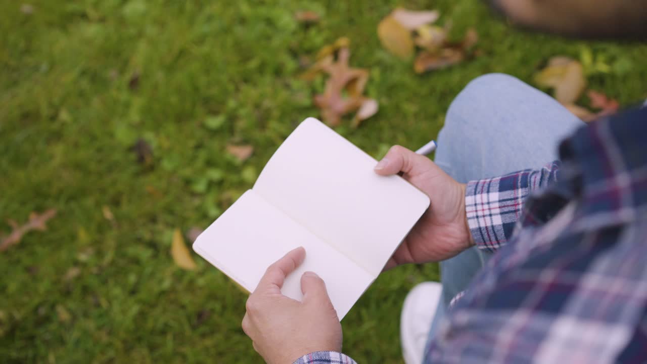 A man pondering on what he is going to right in his notebook
