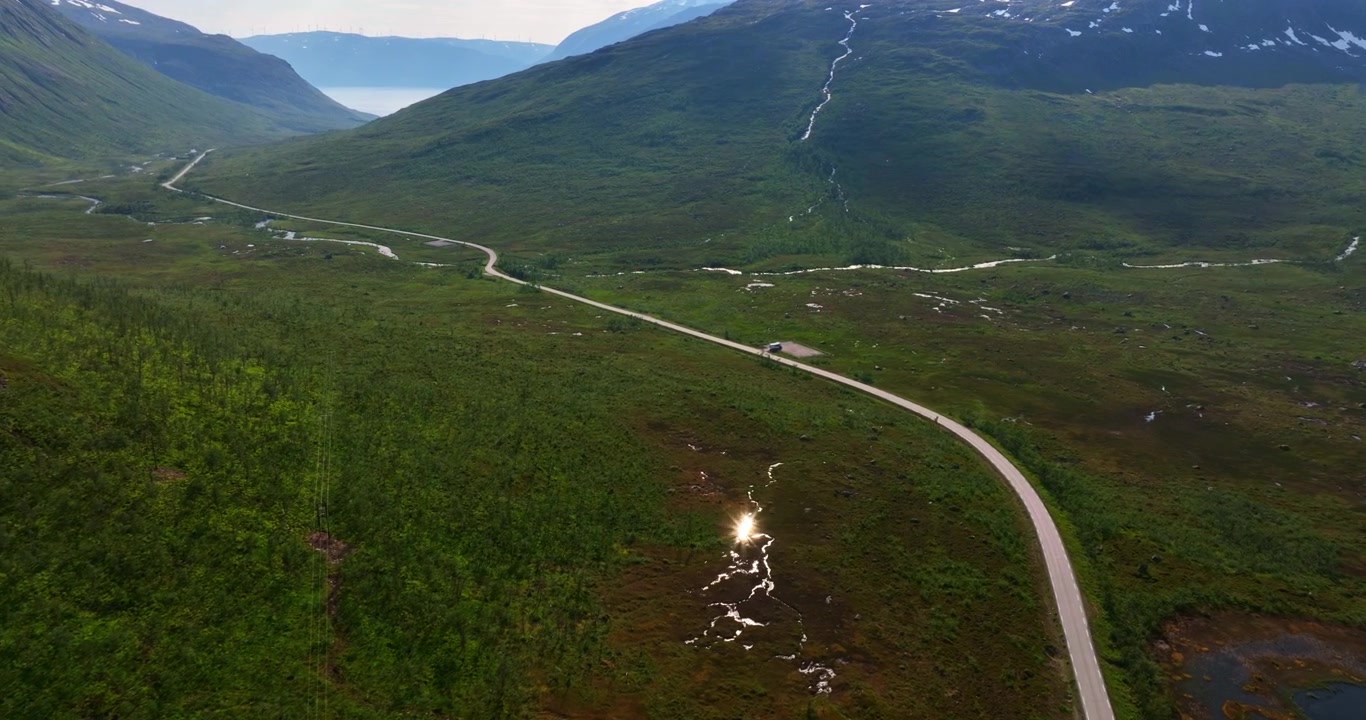 Luftfoto, der følger en højlandsvej, midt i bjergene i Troms i Norge