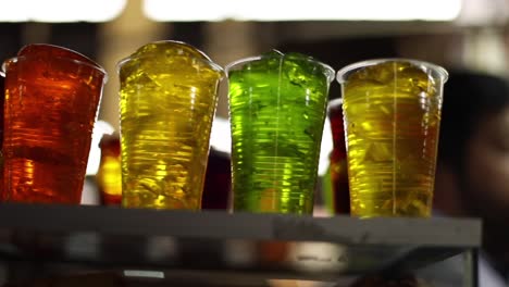 a slider shot of different coloured drinks in a peruvian market