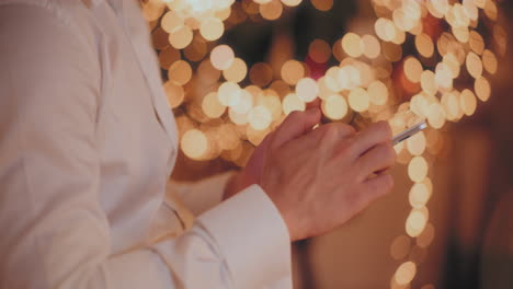 hombre usando una tableta digital en una casa iluminada durante la navidad