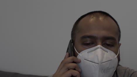 Asian-Adult-Male-With-N95-Face-Mask-Indoors-Talking-On-Mobile-Phone