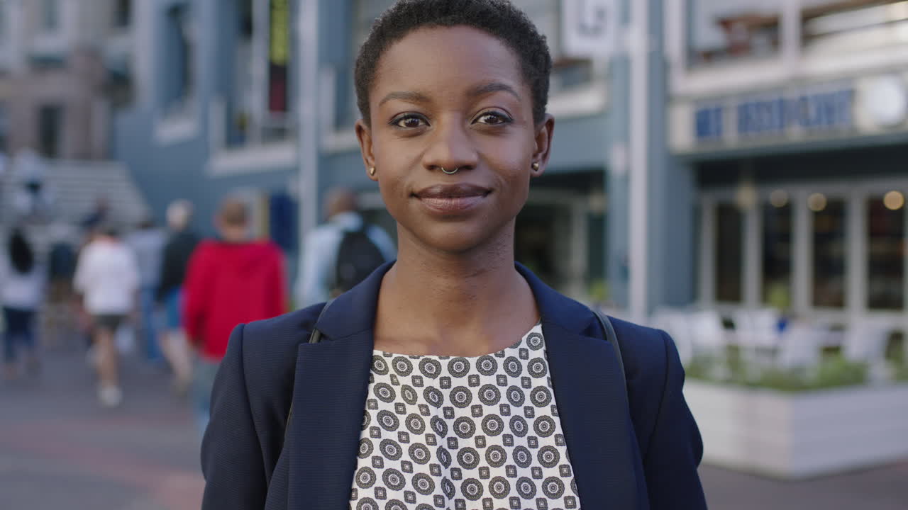 retrato de una mujer de negocios afroamericana independiente que busca seriedad y confianza en la cámara en el fondo urbano