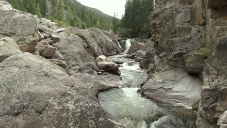 aerial dolly over river with small waterfalls in canyon in colorado