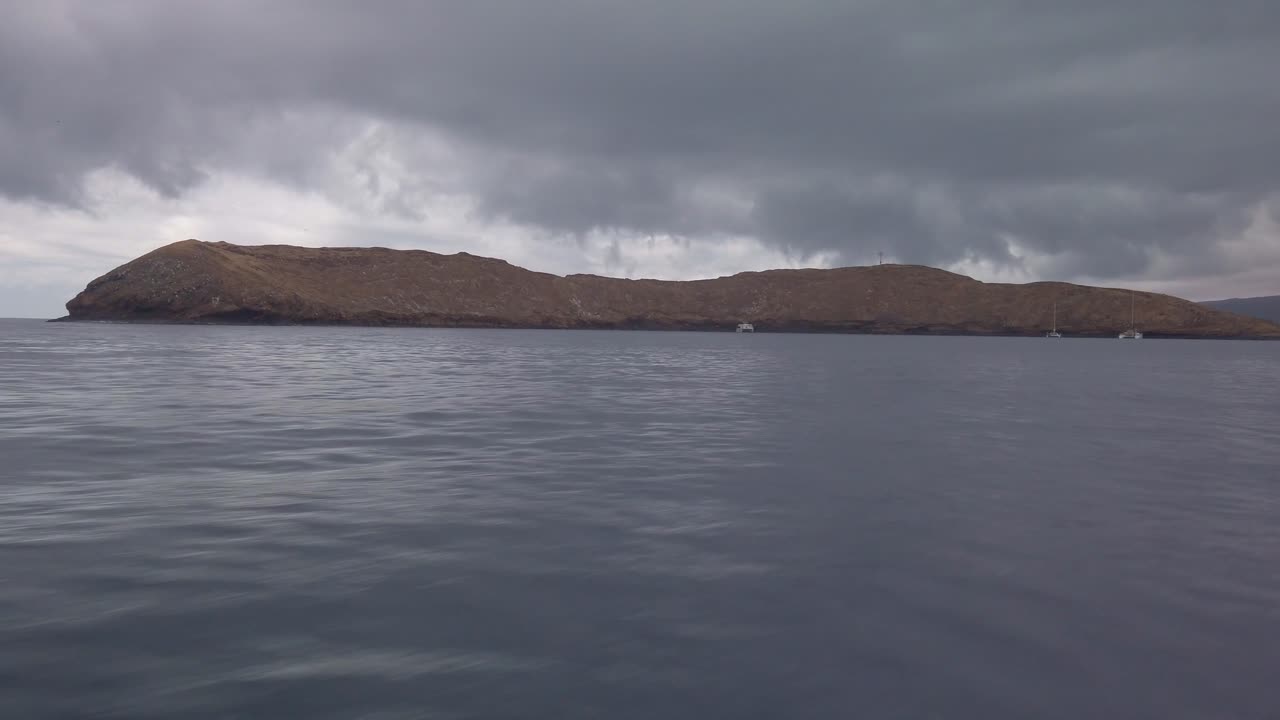 Gimbal close-up POV shot from a moving boat approaching Molokini Crater off the coast of Maui, Hawai'i