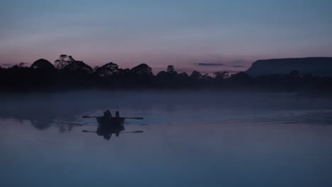 proa de remo en el río cubierto de niebla al atardecer