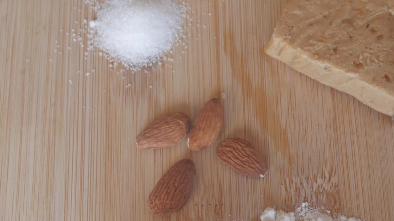 Almonds and flour on wooden board, key for soft Spanish turron de almendra