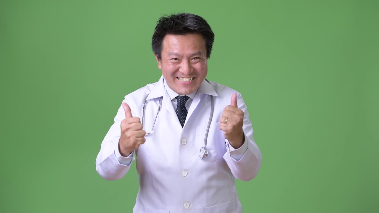 성숙한 일본인 남성, 초록색 배경의 의사