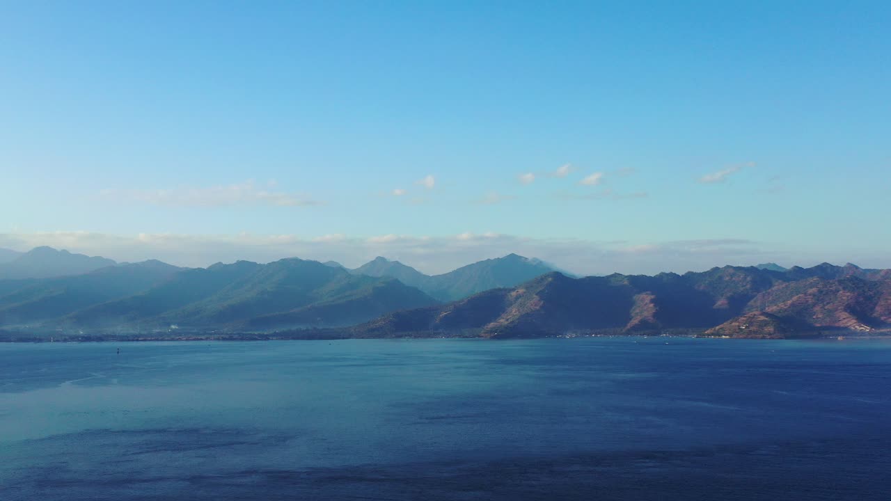 인도네시아 아침 안개 낀 하늘 아래 넓은 바다와 화산섬의 높은 산의 평화롭고 아름다운 블루스