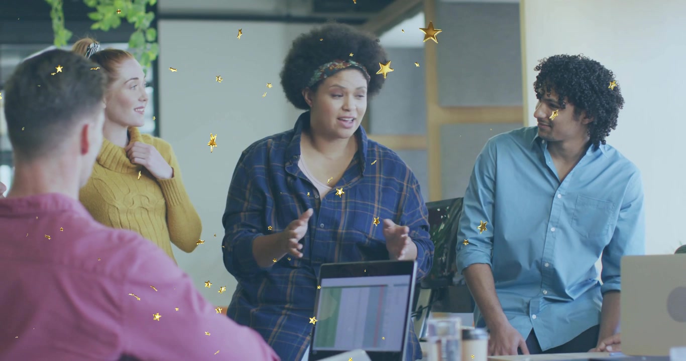 Presenter standing launching office pitch, gesturing while gold stars floating around team laptop