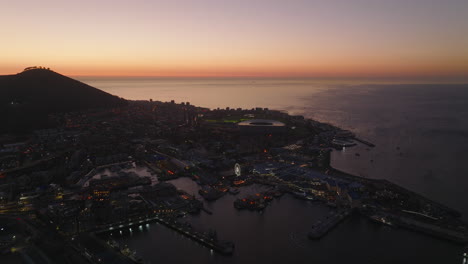 Toma-Aérea-Del-Municipio-Urbano-En-La-Costa-Del-Mar.-Foto-Romántica-De-La-Ciudad-Y-Aguas-Tranquilas-Bajo-Un-Cielo-Colorido.-Ciudad-Del-Cabo,-Sudáfrica