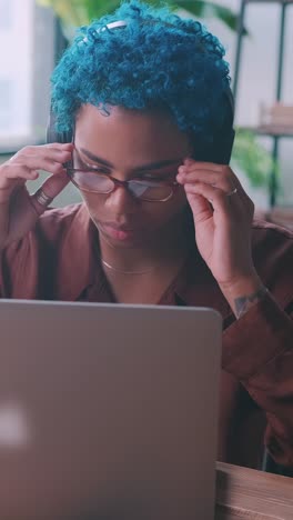 young african american woman student listens to music and works with laptop