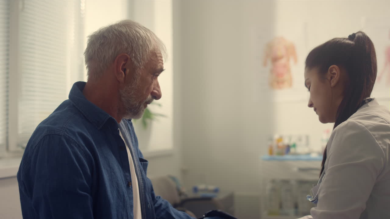 Cardiologa che controlla la pressione sanguigna di un pensionato usando un tonometro, primo piano.
