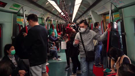 crowded train with people wearing masks during covid 19 pandemic in china, hong kong