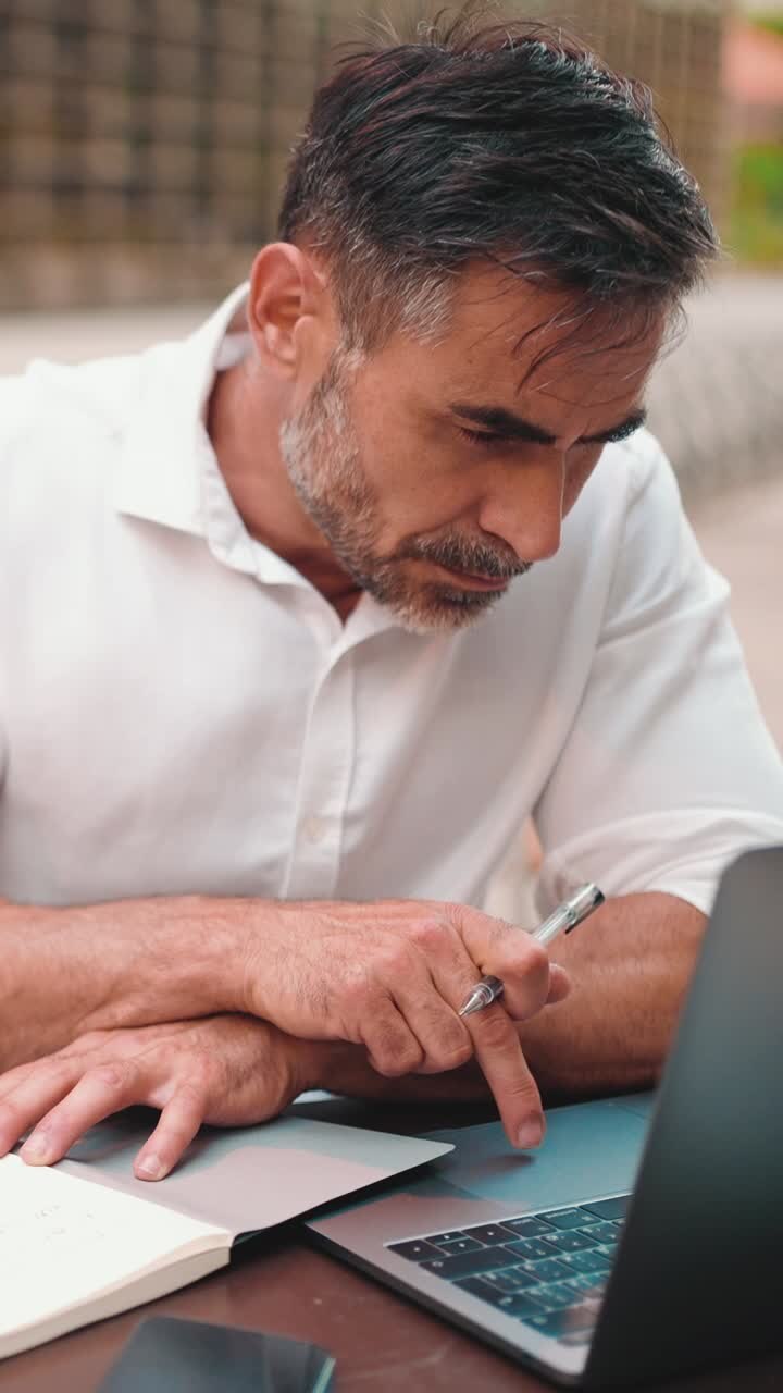 Man working on laptop with notebook
