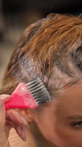 this closeup shows the artistic hair coloring process, highlighting careful dye application on textured hair