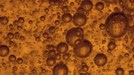 arising air bubbles in a thick orange gel