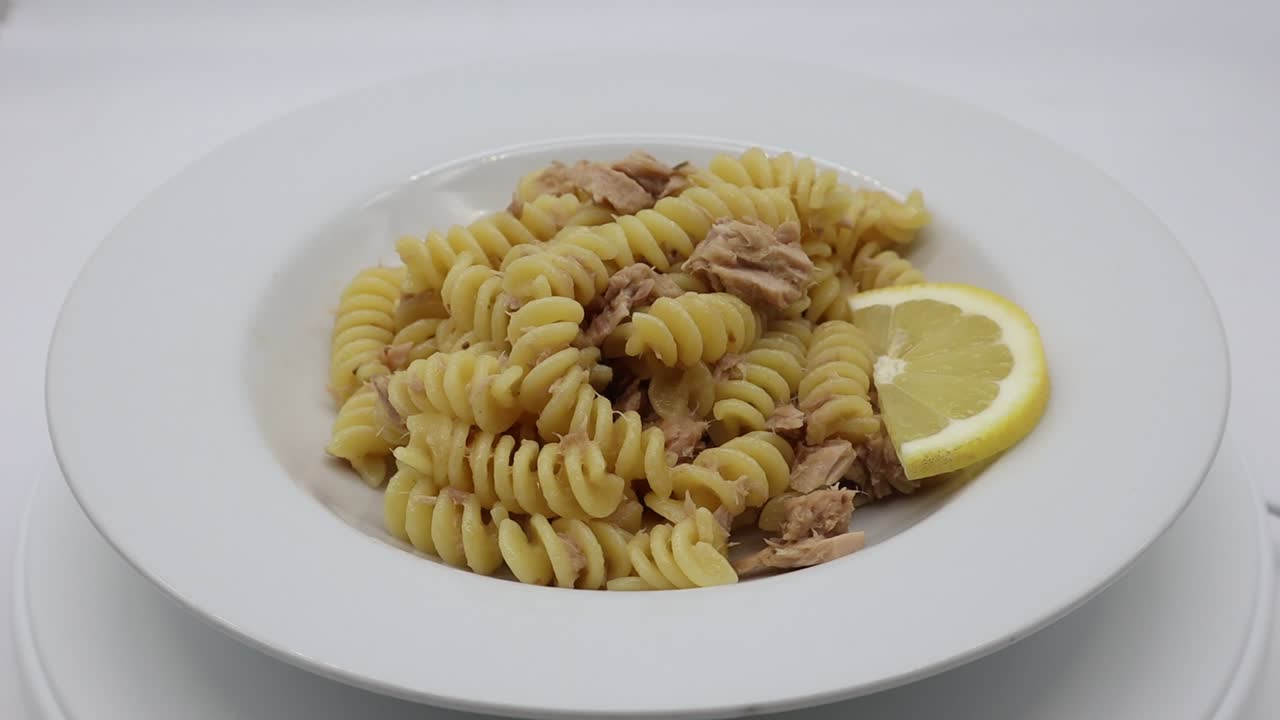 이탈리아의 푸실리 파스타는 색 접시에 과 레몬을 넣습니다.