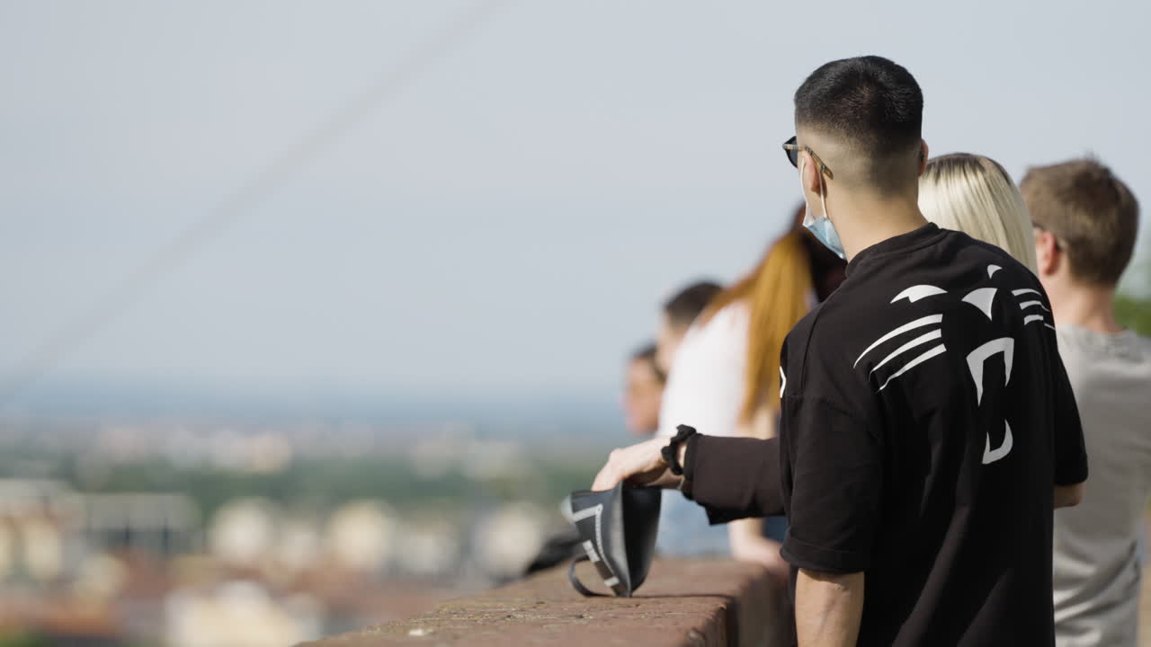 슬로우 모션 장면에서 흐릿한 도시 스카이라인을 바라보는 관광객