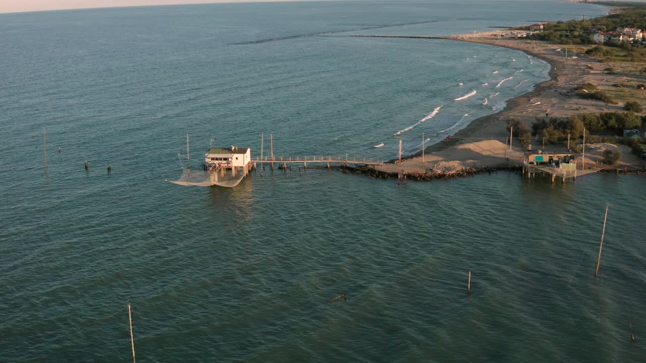 toma aérea de los valles cerca de ravenna donde el río desemboca en el mar con las típicas cabañas de pescadores