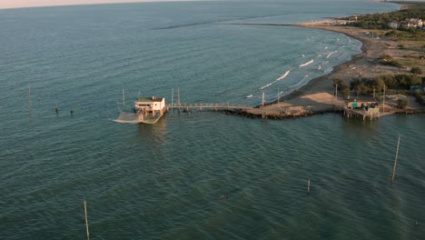 Aerial-shot-of-the-valleys-near-Ravenna-where-the-river-flows-into-the-sea-with-the-typical-fishermen's-huts