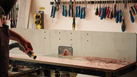 woodworker cleaning spindle moulder machine after finishing client project