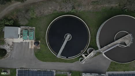 rotating arms are cleaning a circular sedimentation tank in a water treatment facility near a small solar panel array in amelie les bains palalda, france