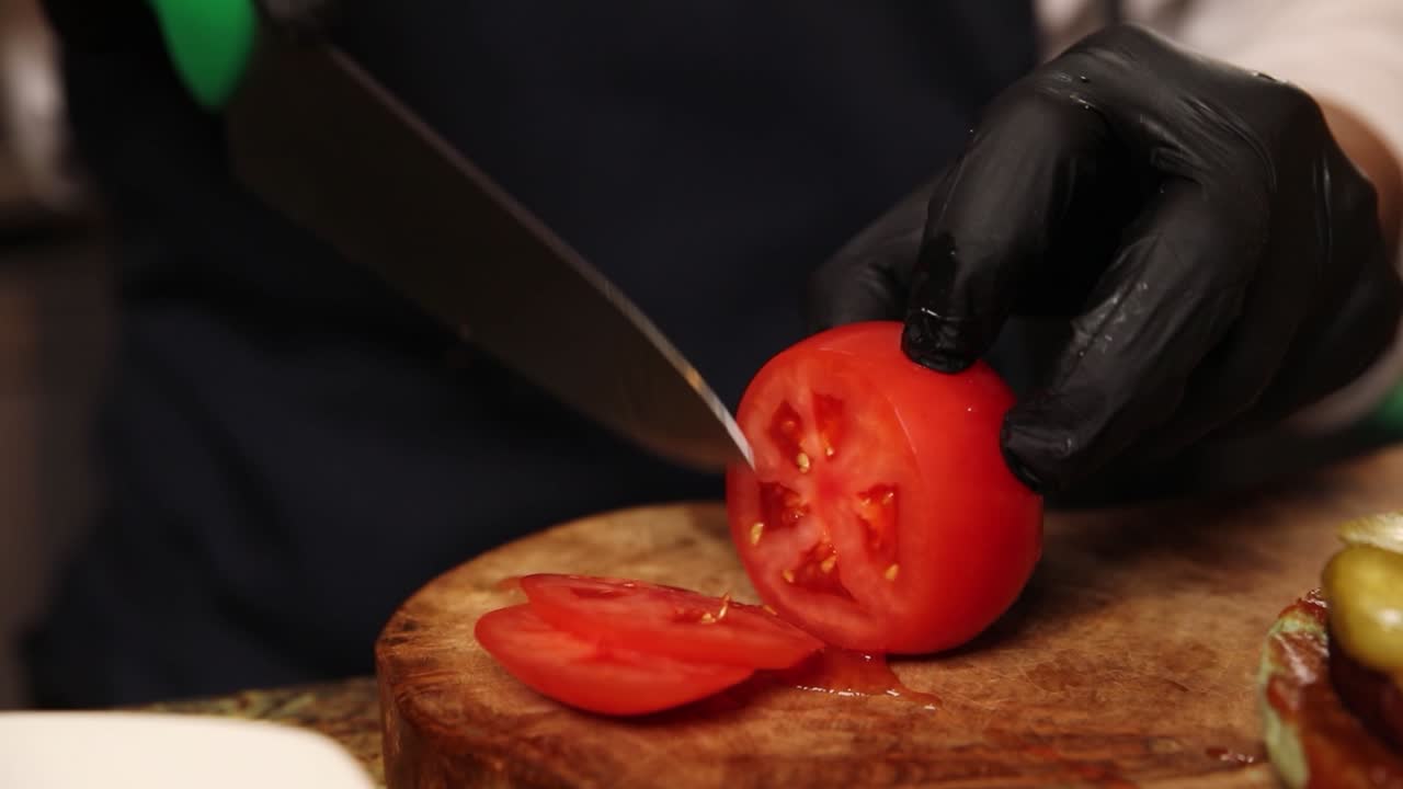 토마토 조각으로 햄버거를 준비하고 있습니다.