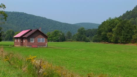 a cabin in the middle of a green field near the allegheny mountains in west virginia pennsylvania