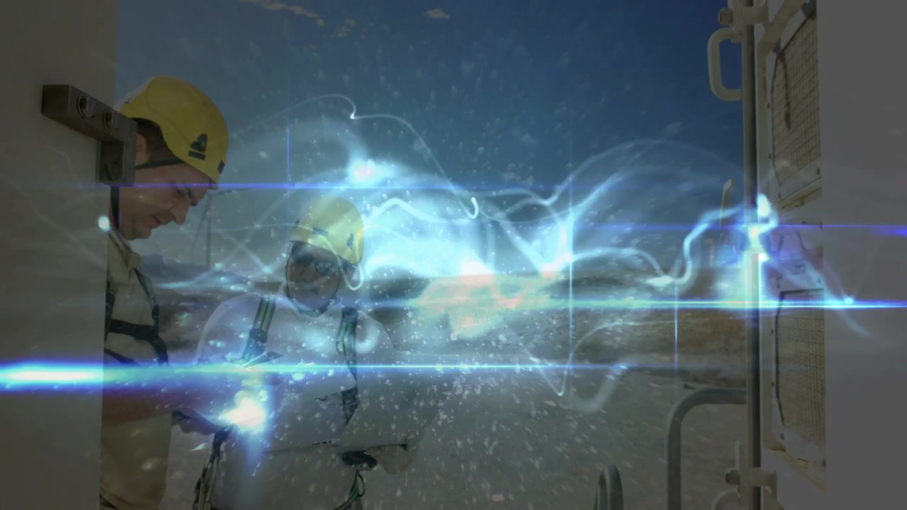Two male construction workers in yellow helmets checking doorway with glowing device and plans