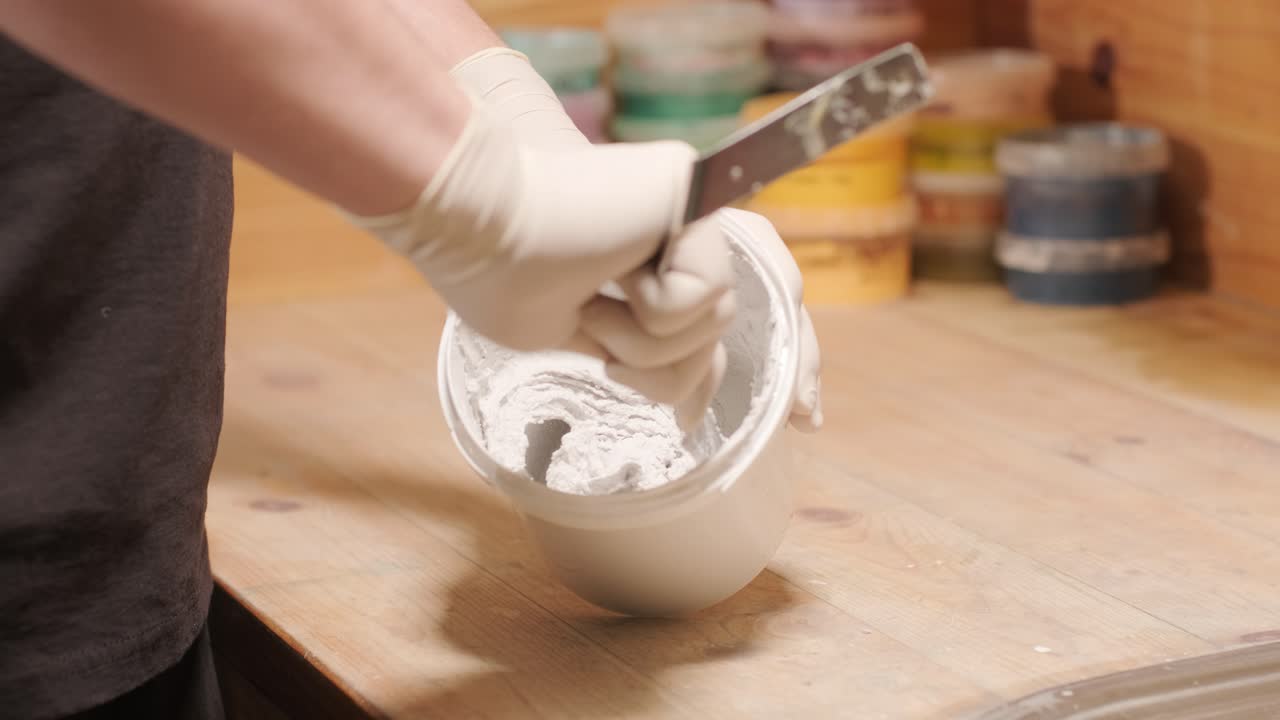 A worker mixes the material for puttying the walls