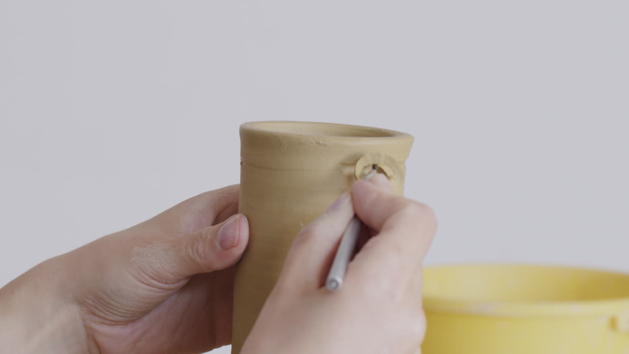 Pottery making: shaping a clay cup handle
