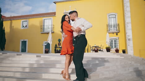 latin dance performers moving passionately on city stairs. couple performing