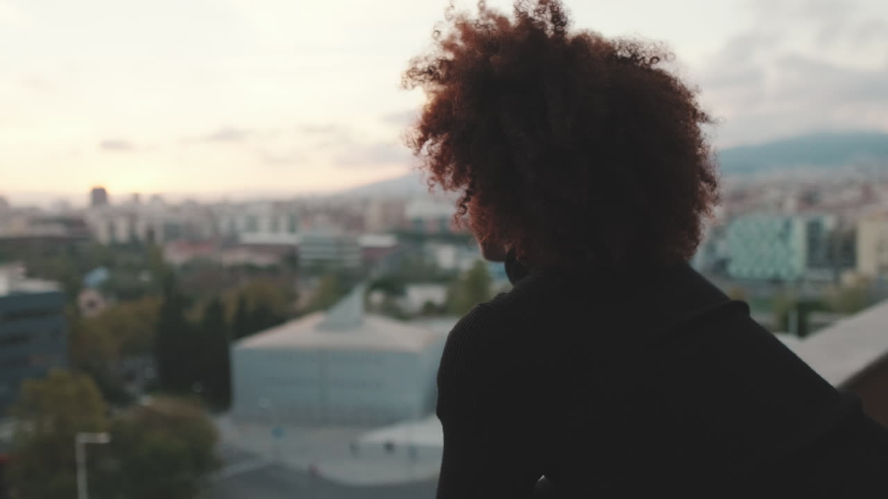 Woman Contemplating Cityscape at Sunset