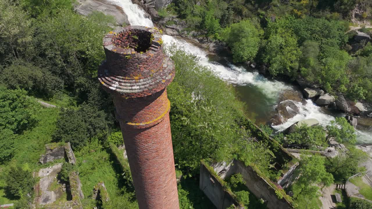 Old Brick Chimney At The Ruins Of Fabrica da Luz Near Fervenza de Segade In Pontevedra, Spain. Aerial Drone Shot