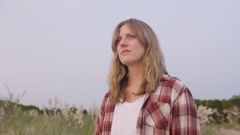 handheld shot of a young woman looking out from a beach