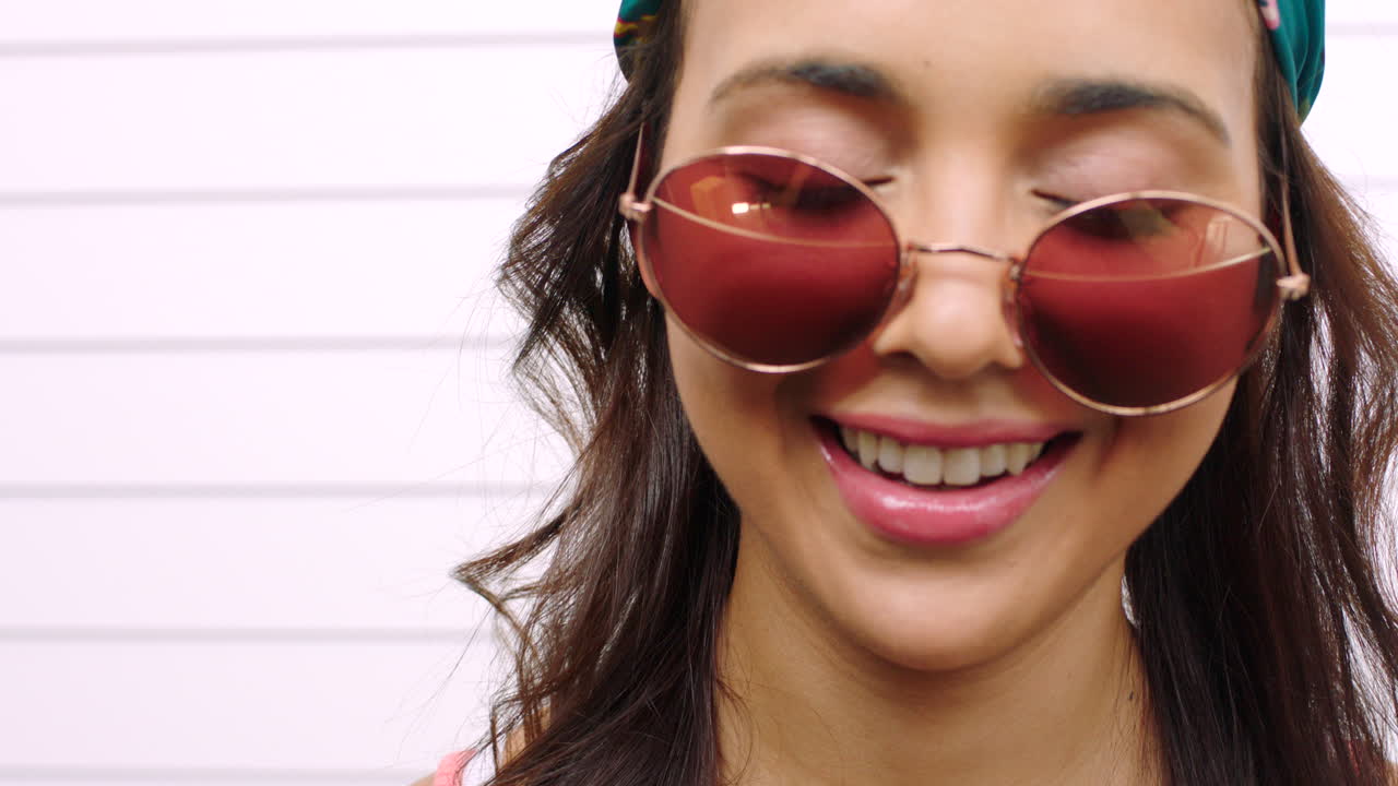 primer plano de una mujer de moda riendo en madera blanca