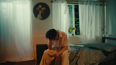 Man Sitting in a Bedroom