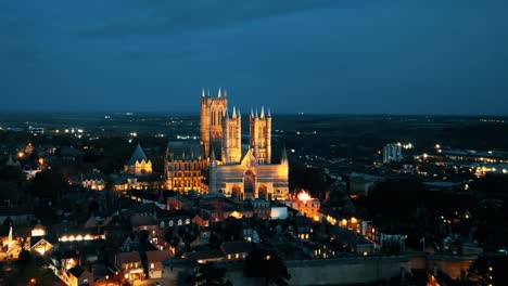 Aerial-drone-video-captures-the-renowned-Lincoln-Cathedral-in-Lincolnshire,-UK,-at-dusk,-showcasing-its-majestic-Gothic-architecture-with-illumination