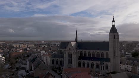 drone shot of a church in a city center on a cloudy day before sunset.